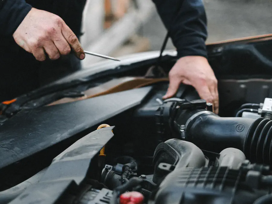 A mechanic checking under the bonnet of a car.